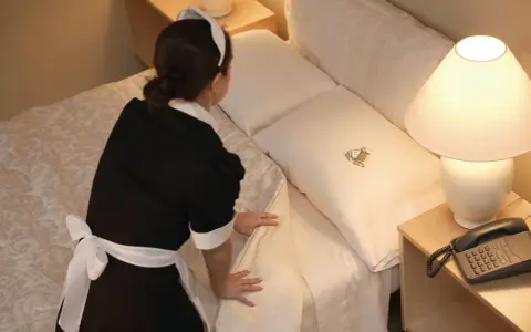 Pokojówka sprząta hotelowe łóżko, na którym leżą dwa cukierki. Czy można wynająć pokój w hotelu na parę godzin?