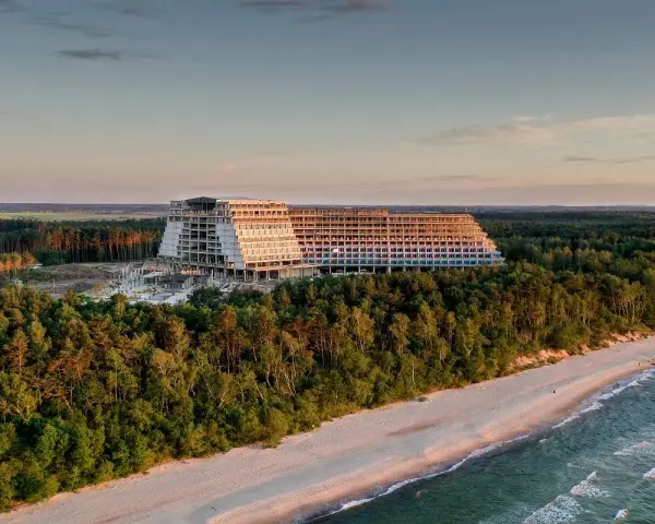 Ogromny, niedokończony hotel, który ma być największym hotelem w Polsce, góruje nad lasem i plażą o zachodzie słońca.