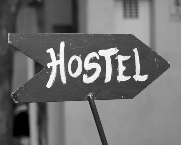 Strzałka z napisem "Hostel" wzywa podróżnych do taniego noclegu. To miejsce, gdzie poznasz innych wędrowców.