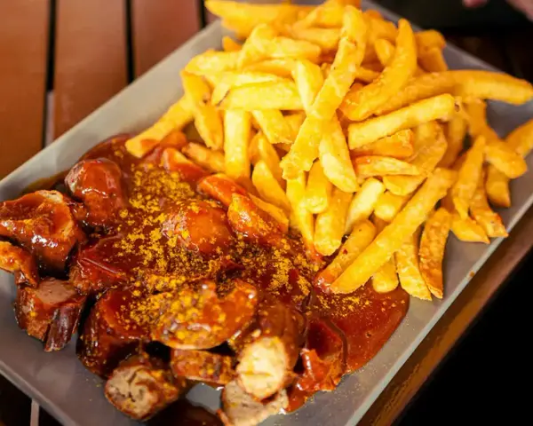 Currywurst z frytkami, klasyka, co zjeść w Berlinie. Pyszne danie na talerzu.