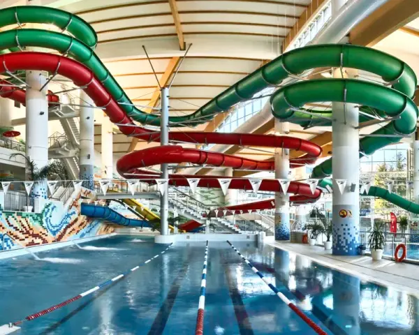 Wesoły aquapark z hotelem oferuje zjeżdżalnie w kolorach czerwonym i zielonym, basen i mnóstwo zabawy.