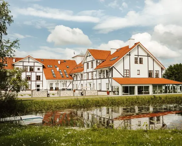 Malowniczy widok na narie resort & spa z łódką przy brzegu i odbiciem w wodzie.