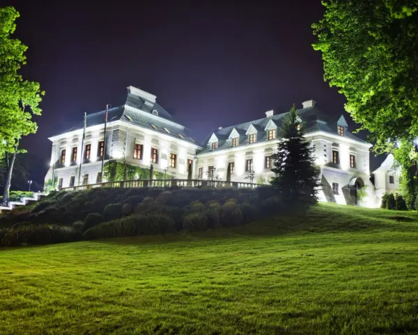 Elegancki hotel z atrakcjami dla dorosłych, nocą oświetlony, z pięknym ogrodem i zielonym trawnikiem.
