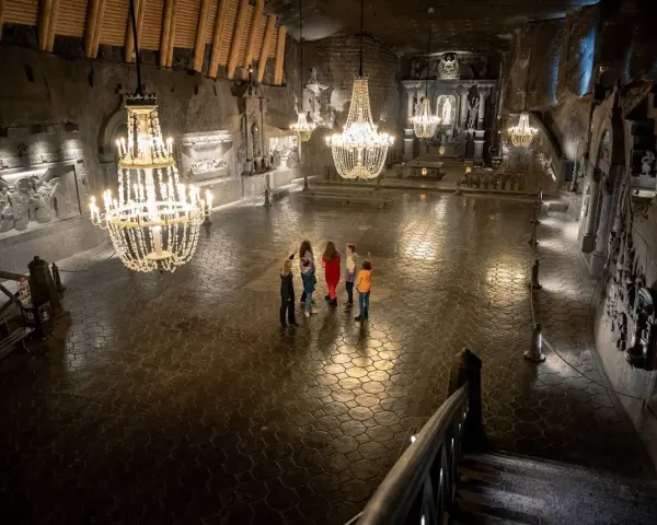 Rodzina zwiedza Kaplicę św. Kingi w Kopalni Soli Wieliczka. Bilety do kopalni warto kupić online.