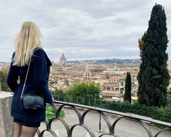 Blondynka podziwia panoramę Rzymu w listopadzie. Pochmurna pogoda nie przeszkadza w zwiedzaniu.