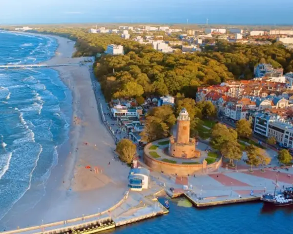 Malownicze miasta nad morzem z latarnią morską, plażą i portem.