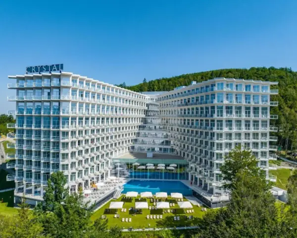 Nowoczesny hotel Crystal w Wiśle, z basenem i tarasami, otoczony zielenią. Idealne miejsce na górski relaks w Wiśle Mountain Spa.