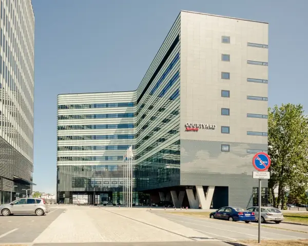 Nowoczesny budynek Courtyard by Marriott w Gdyni, z charakterystyczną, falistą fasadą i przeszklonym parterem.