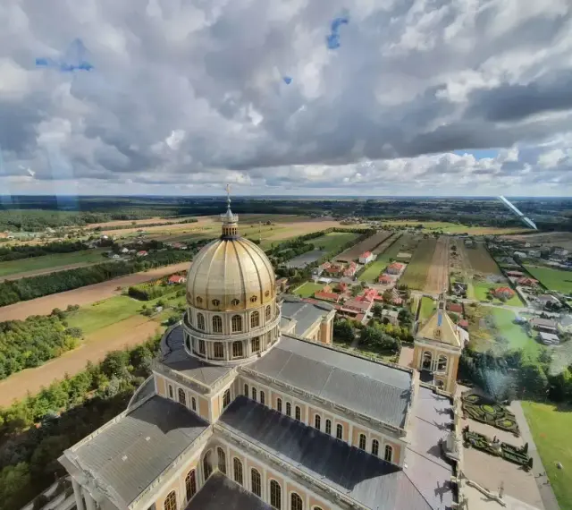 Bazylika w Licheniu z lotu ptaka. Widok na złotą kopułę i okoliczne pola. Sprawdź licheń cennik atrakcji.