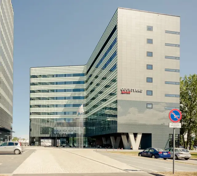 Nowoczesny budynek Courtyard by Marriott w Gdyni, z charakterystyczną, falistą fasadą i przeszklonym parterem.