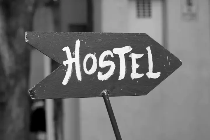 Strzałka z napisem "Hostel" wzywa podróżnych do taniego noclegu. To miejsce, gdzie poznasz innych wędrowców.