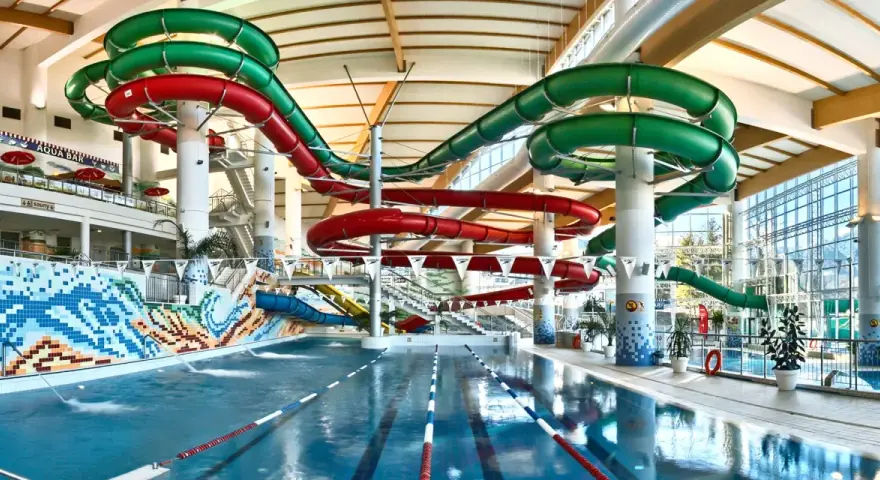 Wesoły aquapark z hotelem oferuje zjeżdżalnie w kolorach czerwonym i zielonym, basen i mnóstwo zabawy.