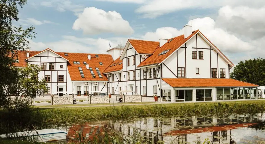 Malowniczy widok na narie resort & spa z łódką przy brzegu i odbiciem w wodzie.