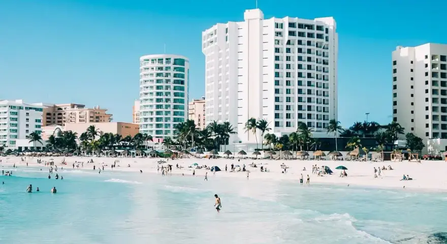 Piękna plaża z turkusową wodą i hotelami w tle. Zastanawiasz się, ile się leci do Meksyku, by tu dotrzeć?