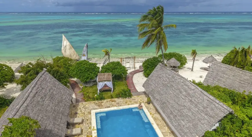Zanzibar w lutym: słoneczna pogoda, turkusowe morze, palmy i urocze domki z krytymi dachami. Idealne miejsce na relaks.