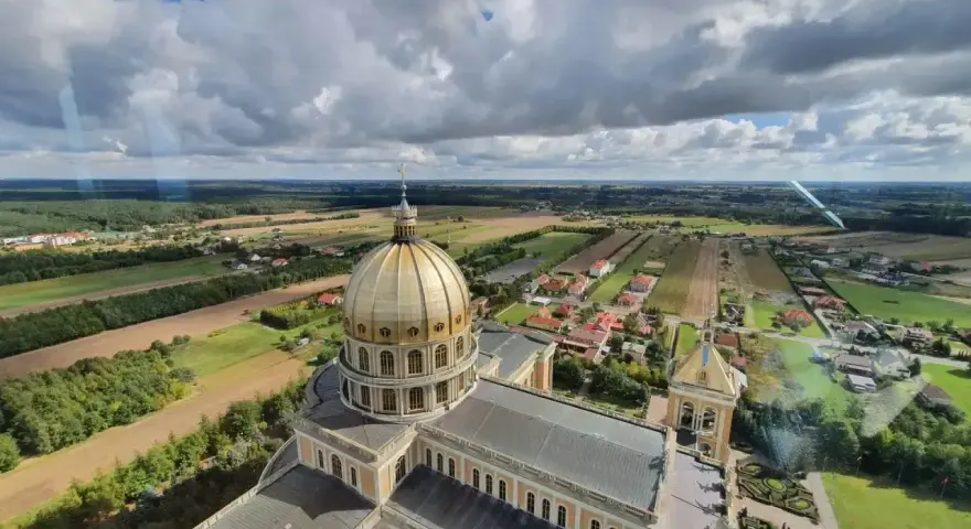 Bazylika w Licheniu z lotu ptaka. Widok na złotą kopułę i okoliczne pola. Sprawdź licheń cennik atrakcji.
