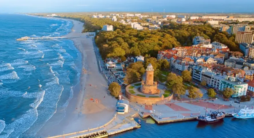 Malownicze miasta nad morzem z latarnią morską, plażą i portem.