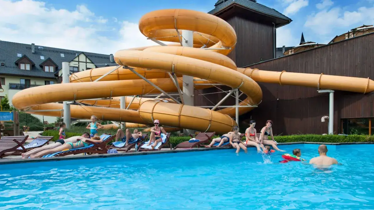 Rodzina odpoczywa przy basenie w aquaparku w Karpaczu. Sprawdź aquapark Karpacz cennik i zaplanuj wakacje!