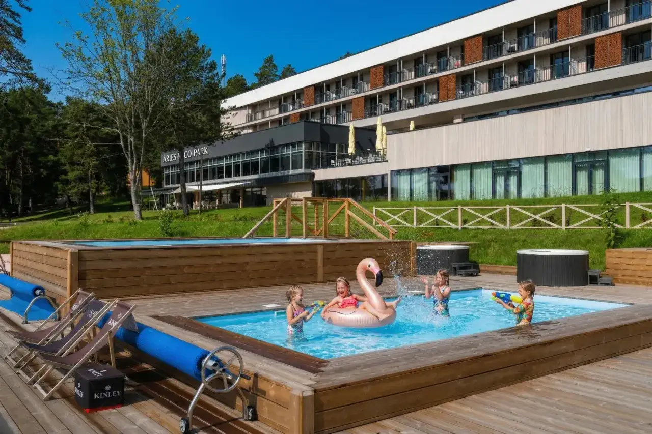 Dzieci bawią się w basenie z dmuchanym flamingiem. Idealne mazury all inclusive dla rodzin.