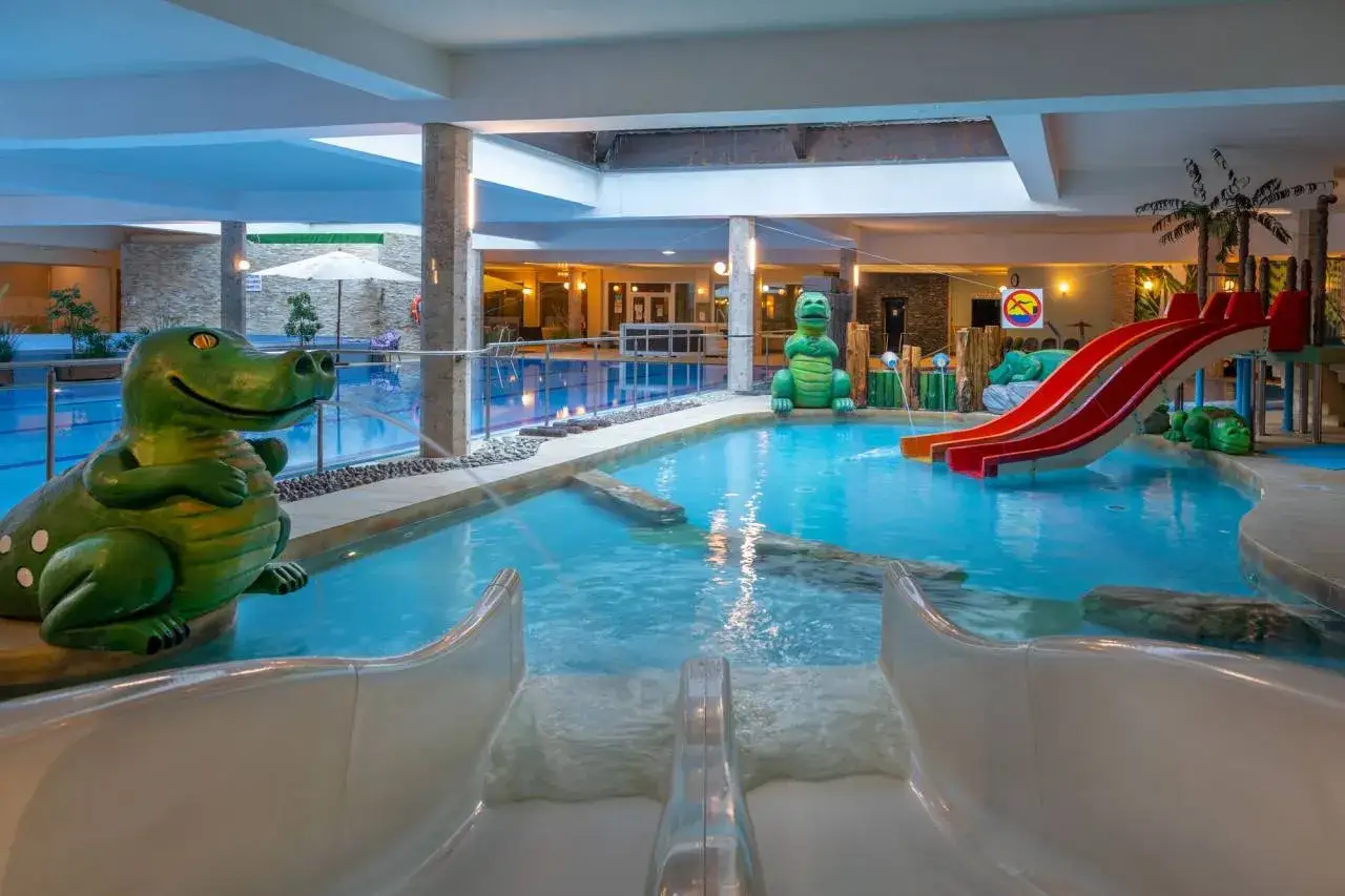Wesoły karpacz hotel z aquaparkiem, gdzie zielone dinozaury strzegą basenu ze zjeżdżalniami.