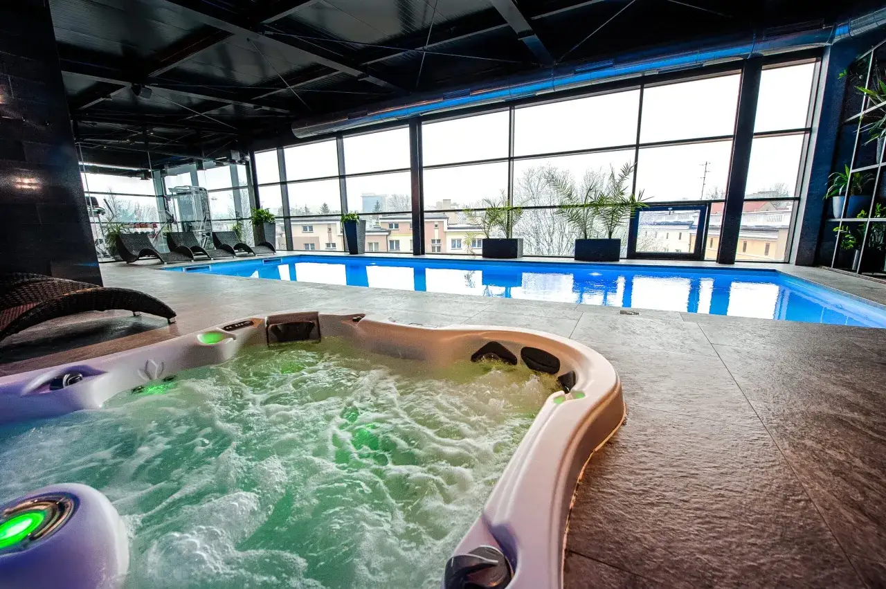 Relaks w jacuzzi i basenie w hotel spa Białystok. Duże okna z widokiem na miasto.