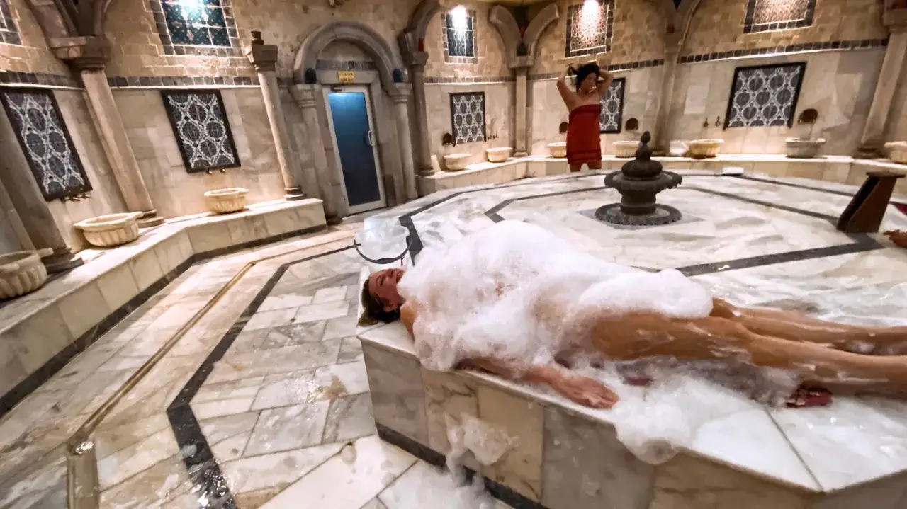 Kobieta w pianie w łaźni hammam. To tradycyjne tureckie łaźnie parowe, gdzie można się zrelaksować i oczyścić ciało.