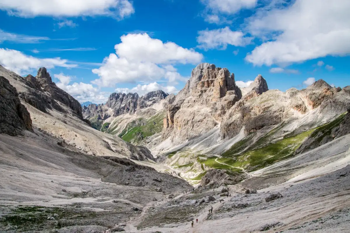 Malownicze Val di Fassa w Dolomitach. Kręta ścieżka prowadzi przez skaliste zbocza i zielone hale, podziwiając majestatyczne szczyty.