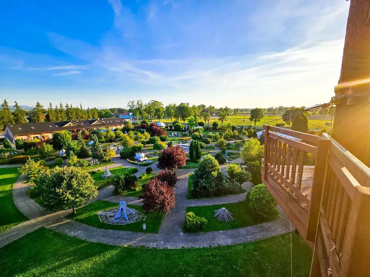 Widok z góry na zielony, zadbany park z alejkami i miniaturowymi budowlami. To idealne miejsce na rodzinne wycieczki, prawdziwy dream park w Ochabach.