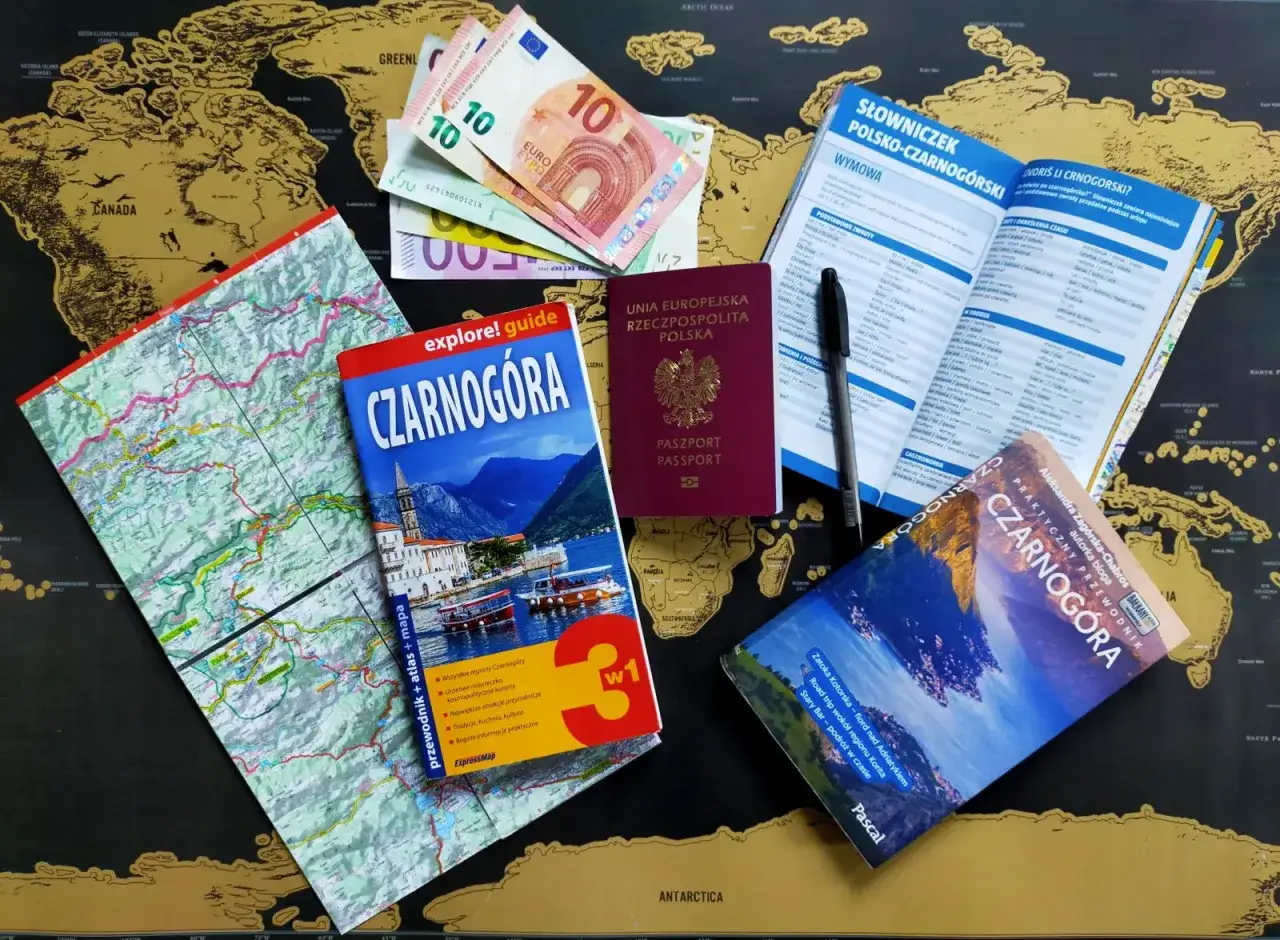 Przygotowania do podróży do Czarnogóry: paszport, euro, mapy, przewodnik i słowniczek polsko-czarnogórski.