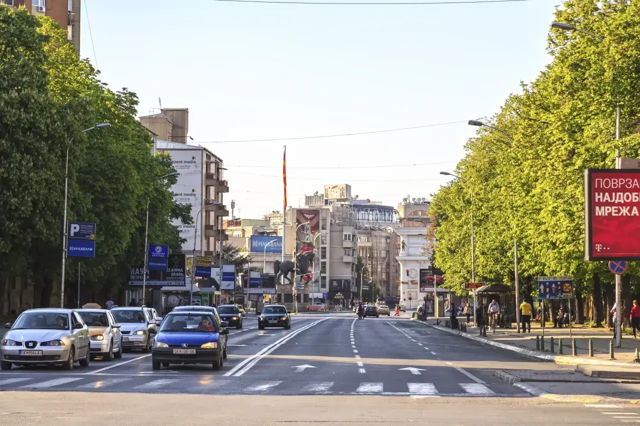 Ulica w Skopje, Macedonia, z samochodami i zielenią. Loty do Macedonii są popularne.
