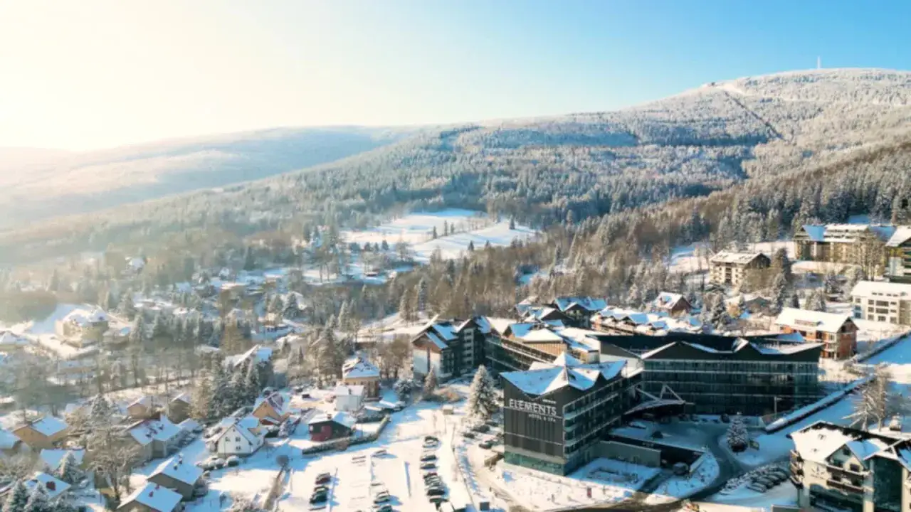 Malowniczy hotel ze stokiem narciarskim dla dzieci w otoczeniu ośnieżonych gór i lasów. Idealne miejsce na zimowy wypoczynek.