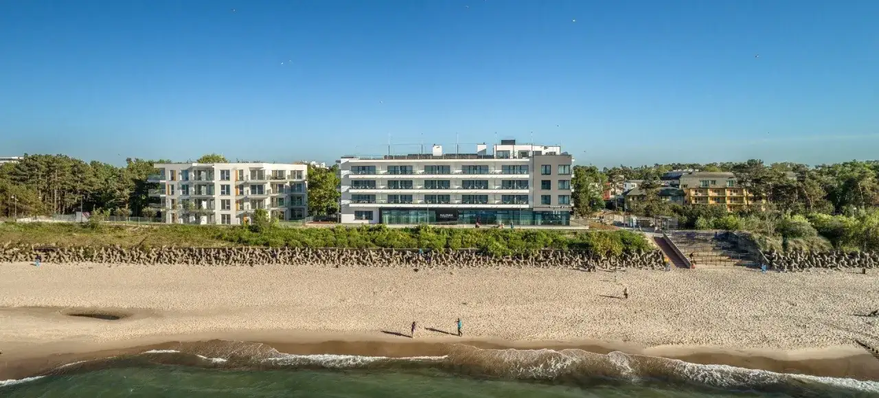 Nowoczesny hotel nad samym morzem, z tarasami i widokiem na plażę. Idealne miejsce na wakacje.