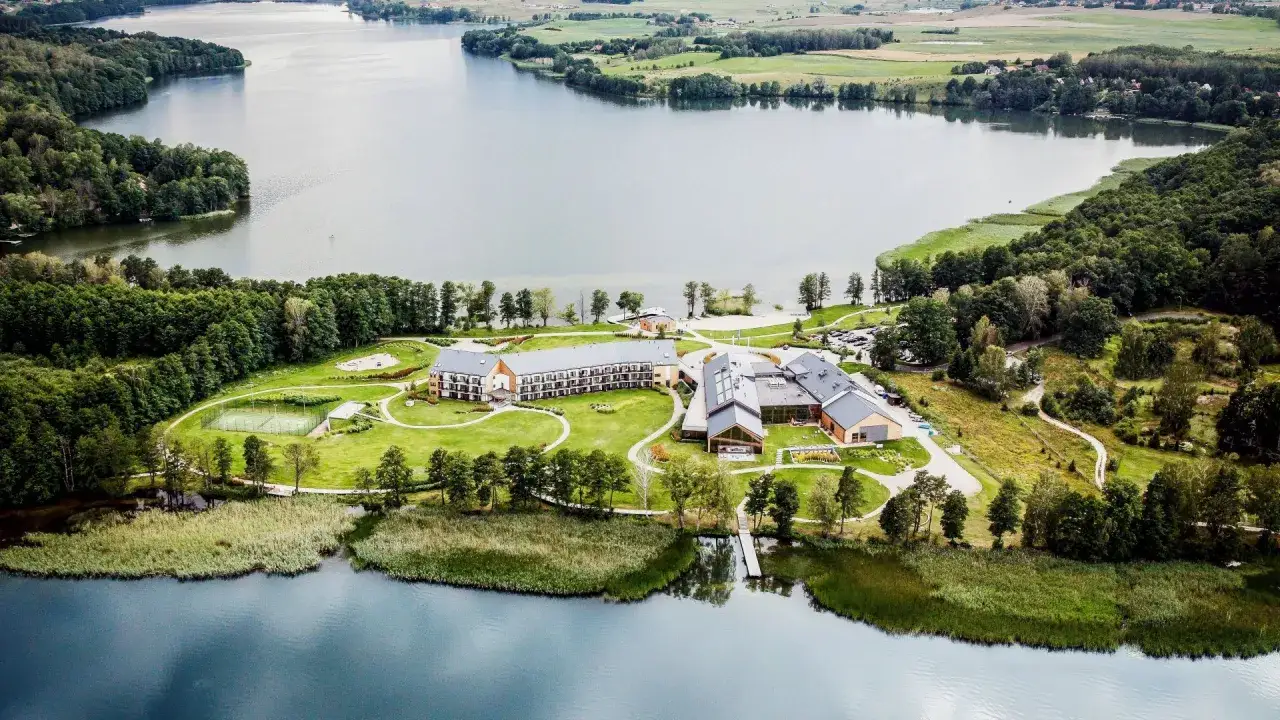 Nowoczesny hotel nad jeziorem, idealne miejsce na konferencje na Mazurach. Otoczony zielenią, z kortem tenisowym i pomostem.