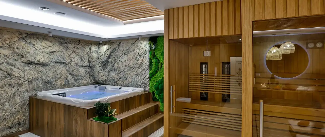 Relaks w jacuzzi i saunie – to oznacza hotel dla dorosłych. Kamienna ściana, mech i drewno tworzą unikalny klimat.