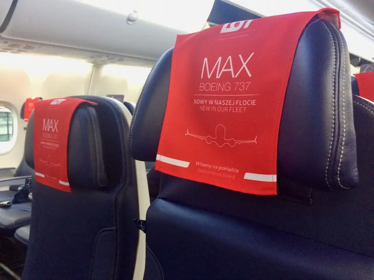 Fotele w klasie biznes LOT Boeing 737 MAX. Czerwone zagłówki z napisem
