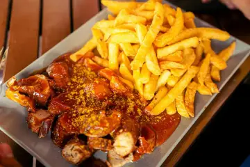 Currywurst z frytkami, klasyka, co zjeść w Berlinie. Pyszne danie na talerzu.