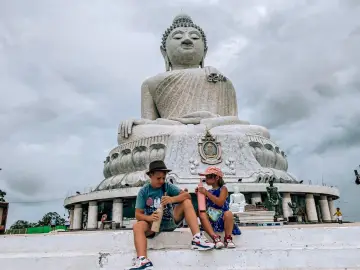Dzieci piją napoje przed Wielkim Buddą, wspaniałym widokiem z Kata Beach.