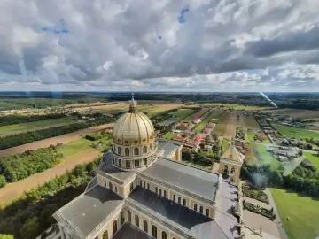 Bazylika w Licheniu z lotu ptaka. Widok na złotą kopułę i okoliczne pola. Sprawdź licheń cennik atrakcji.