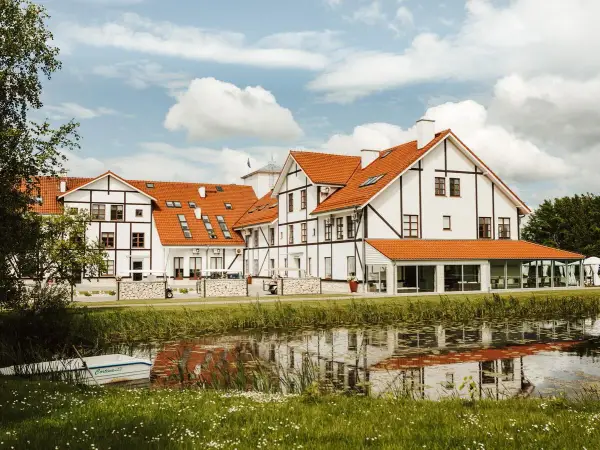 Malowniczy widok na narie resort & spa z łódką przy brzegu i odbiciem w wodzie.