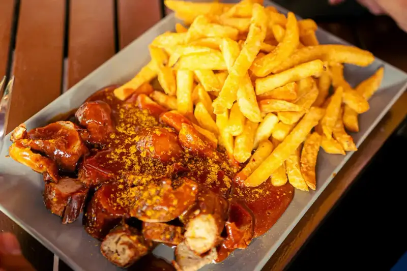 Currywurst z frytkami, klasyka, co zjeść w Berlinie. Pyszne danie na talerzu.