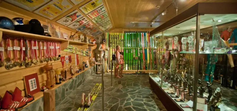 Wnętrze muzeum Adama Małysza w Wiśle. W gablotach i na półkach wyeksponowano medale, puchary, narty i kombinezony skoczka.