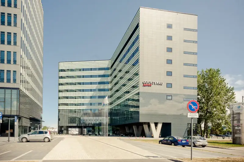 Nowoczesny budynek Courtyard by Marriott w Gdyni, z charakterystyczną, falistą fasadą i przeszklonym parterem.